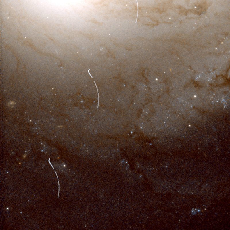 这个残断的小行星轨迹穿过了M91星系的外围。小行星进入图像的顶部中心,并向左下方移动。因为哈勃绕着地球转,它不能不停地盯着这个星系。所以留下了中断的踪迹。图片:NASA/ESA