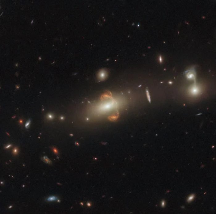 影像正中央有两个看似相同的星系，事实上它们是同一个星系。