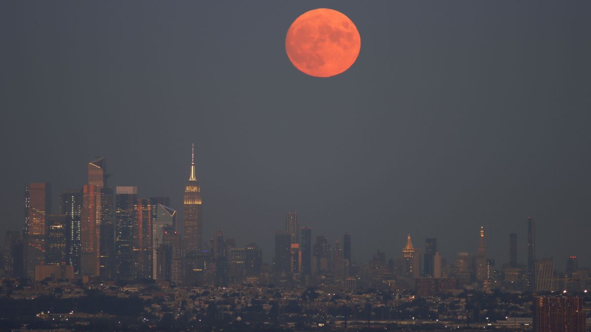 太阳落山时，满月在帝国大厦后升起。(图片来源: Gary Hershorn/Getty Images)