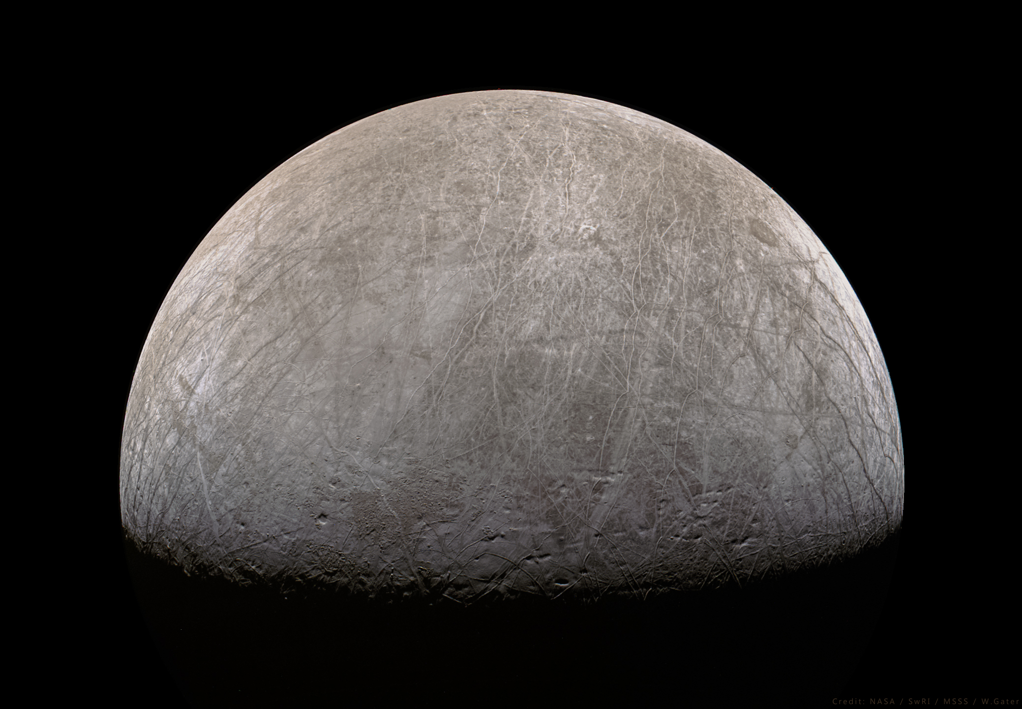 由朱诺号拍摄的欧罗巴圆盘图像，巨大的纵横交错的“网格”覆盖了整个星球。来源: NASA / SwRI / MSSS / W. Gater
