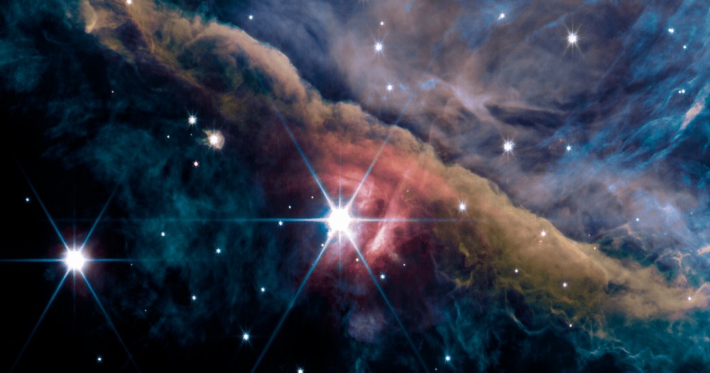 詹姆斯·韦伯太空望远镜的 NIRCam 仪器所看到的猎户座星云的内部区域。该图像是使用詹姆斯韦伯太空望远镜 NIRCam 仪器于 2022 年 9 月 11 日获得的。将不同滤镜中的几张图像组合起来创建了这张合成图像：F140M 和 F210M（蓝色）；F277W、F300M、F323N、F335M 和 F332W（绿色）；F405N（橙色）；以及 F444W、F480M 和 F470N（红色）。（来源：NASA、ESA、CSA、PDRs4All ERS 团队；Salomé Fuenmayor 图片）